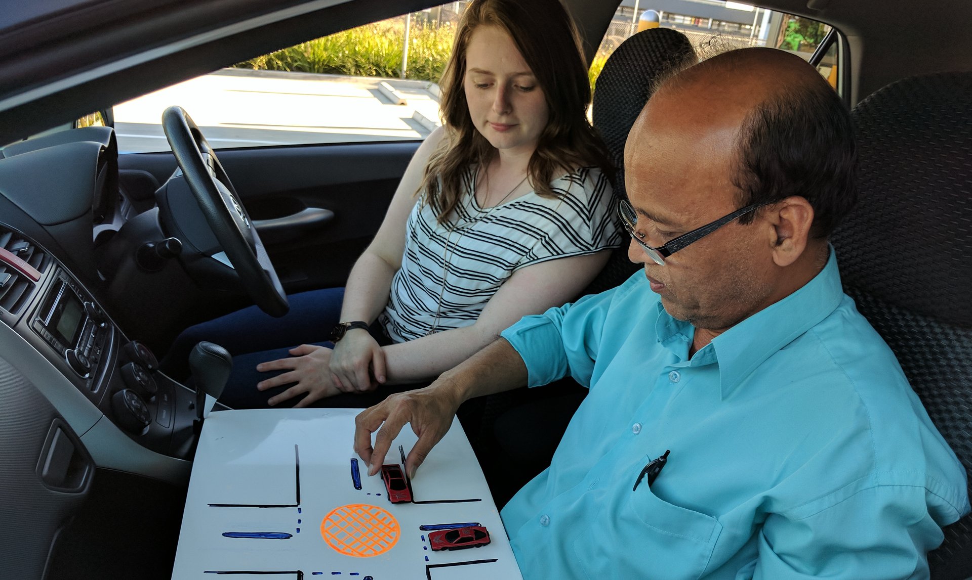Student and instructor in driving lesson with modern car